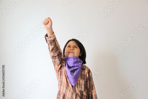 10-year-old Hispanic girl wears a purple headscarf representing the struggle for feminism and gender equality to commemorate International Women's Day on March 8