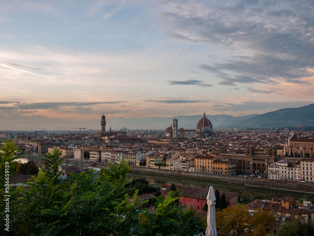 Florence, Italy - October, 2011: panoramic view of Florence City from piazzale Michelangelo. City is covered by orange color during sunset.