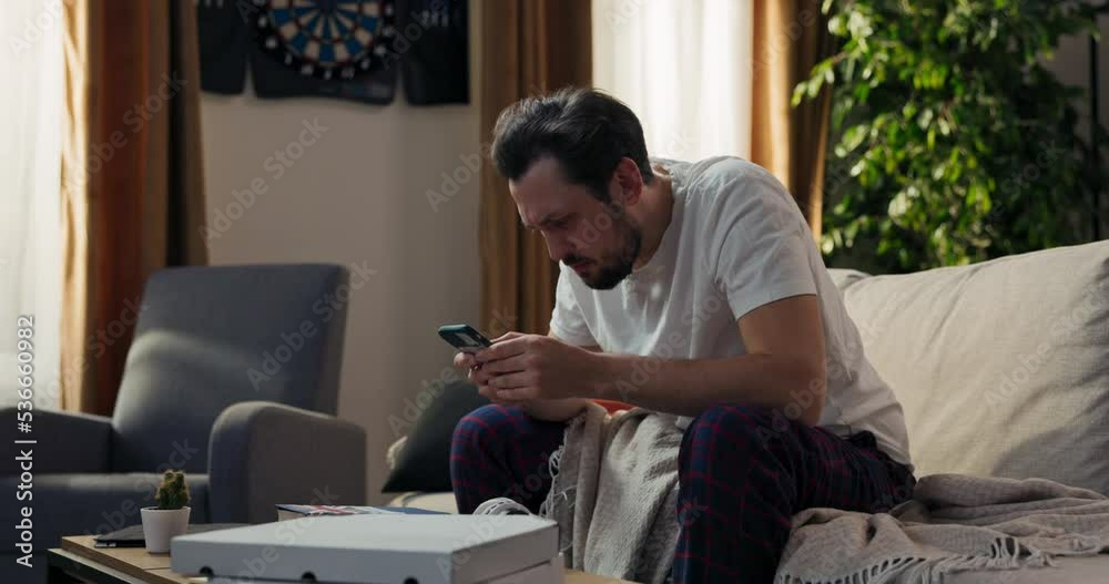 A man after waking up checks messages on phone, an email about an unpaid loan installment, a high electricity and gas bill, the guy catches his head in horror. A man after waking up checks messages on phone, an email about an unpaid loan installment, a high electricity and gas bill, the guy catches his head in horror.