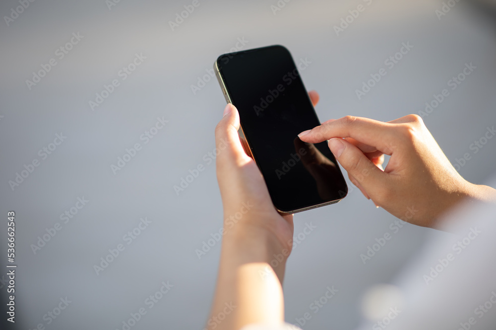 Portrait of a woman holding a smartphone with a blank copy area screen for your text message or content. A woman reading a message on her mobile phone while in town. Portrait of a woman holding a smartphone with a blank copy area screen for your text message or content. A woman reading a message on her mobile phone while in town.