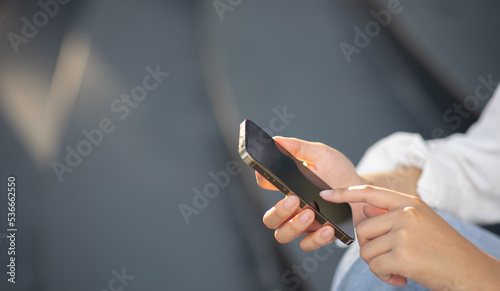 woman using smartphone for online shopping on green nature background in the outdoor park.