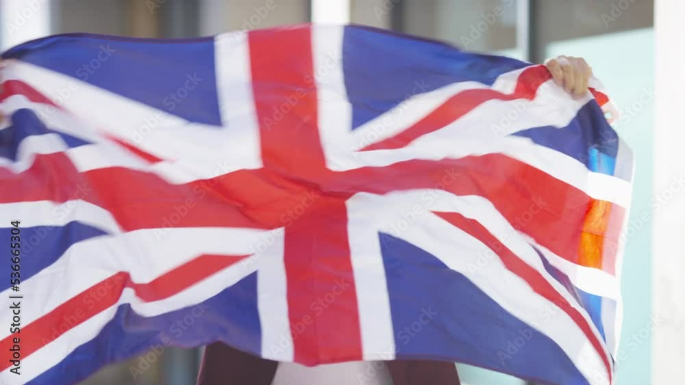 Young energetic man celebrating with a Union Jack flag, in slow motion Young energetic man celebrating with a Union Jack flag, in slow motion