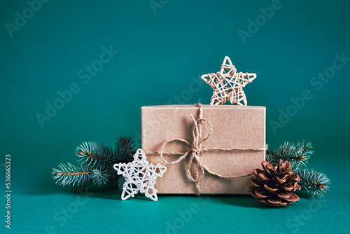 Christmas sustainable composition with craft gift box and natural decor on blue green background. Christmas zero waste