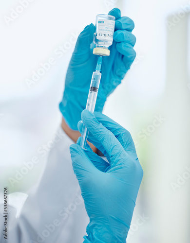 Covid, medicine and vaccine with hands of doctor holding syringe and glass vial for healthcare, pharmacy and science. Innovation, medical and research with pharmacist working on treatment for virus
