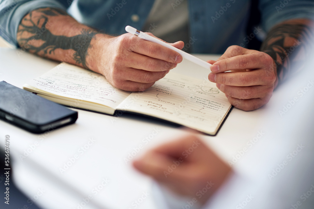 Notebook, meeting and innovation planning with hands of a man writing notes during a discussion with colleague. Closeup of a businessman working on a creative business strategy in a corporate office. Notebook, meeting and innovation planning with hands of a man writing notes during a discussion with colleague. Closeup of a businessman working on a creative business strategy in a corporate office.