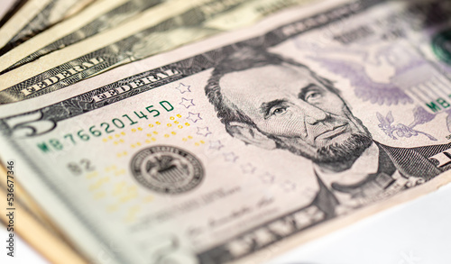 Five dollar bills close up, soft focus.