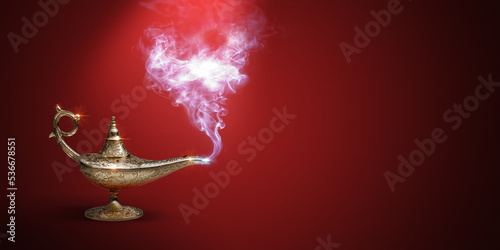 Golden magic lamp on red background photo