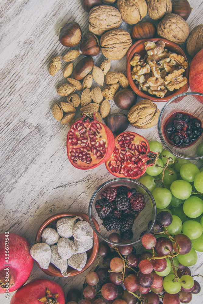 Autumn fruit background.
Autumnal fruit table. Grapes, figs, blackberries, passion fruit, pomegranate and delicious dried fruits. Image with copy space