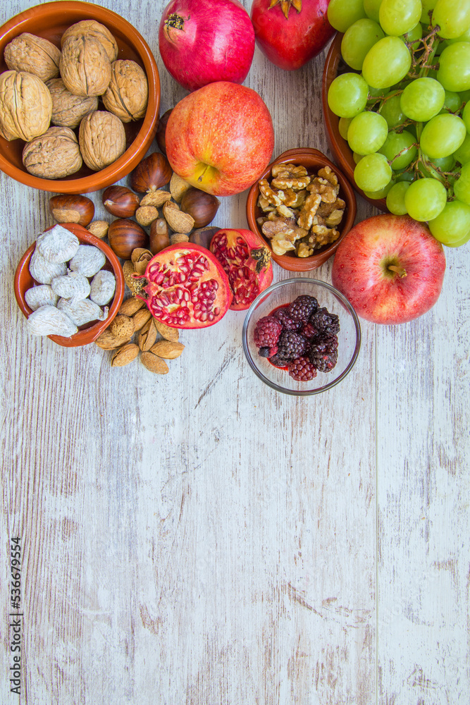 Autumn fruit background.
Autumnal fruit table. Grapes, figs, blackberries, passion fruit, pomegranate and delicious dried fruits. Image with copy space