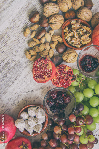 Autumn fruit background. Autumnal fruit table. Grapes, figs, blackberries, passion fruit, pomegranate and delicious dried fruits. Image with copy space
