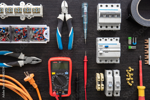Different electrical tools on wooden background, flat lay.
