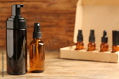 Bottles with oil on wooden table, space for text. Natural cosmetics