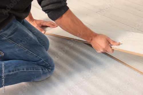 Professional worker installing new laminate flooring, closeup