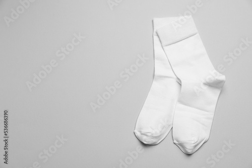 White socks on light grey background, flat lay. Space for text