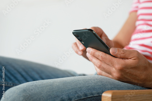 Man using smartphone at home, closeup view. Space for text