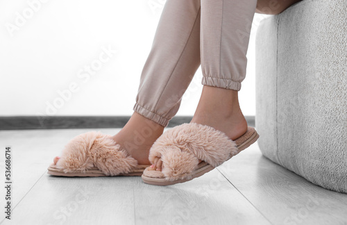 Woman wearing beige soft slippers at home, closeup