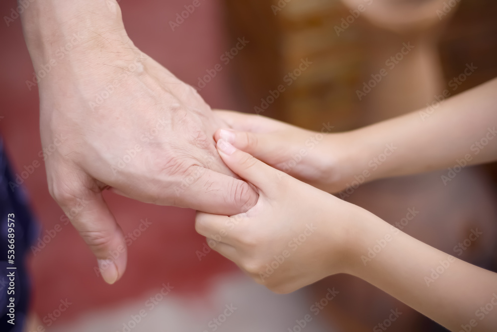 Blurred soft focus asian child girl hand holding father for familly bonding love background close up Blurred soft focus asian child girl hand holding father for familly bonding love background close up