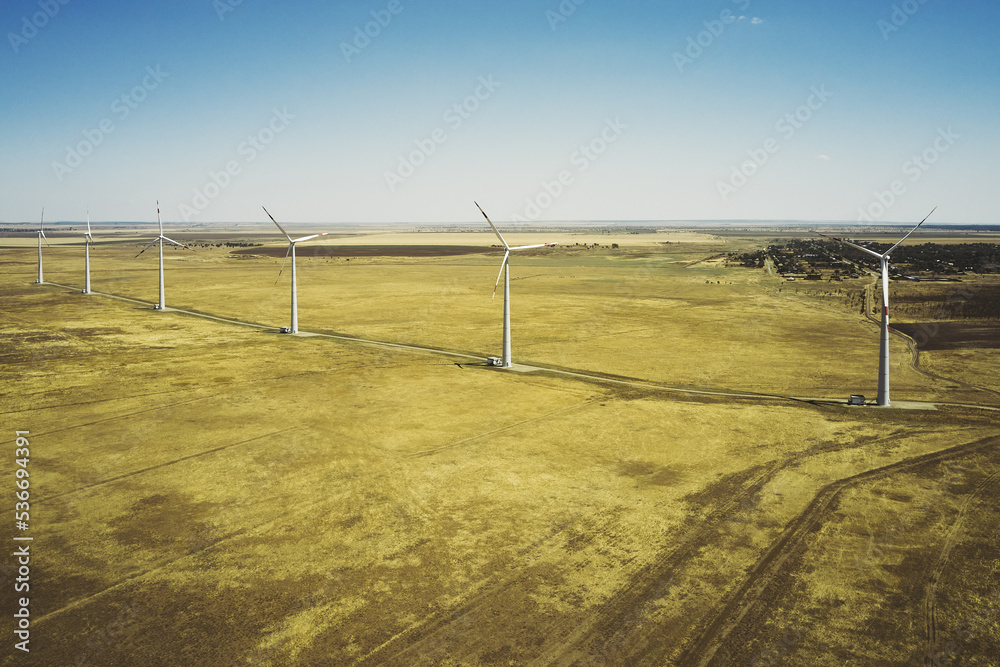 wind power plant in the steppe against the blue sky shooting from a drone
