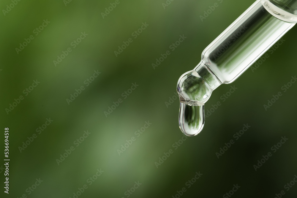 Dripping medical product from pipette against blurred background, closeup. Space for text Dripping medical product from pipette against blurred background, closeup. Space for text