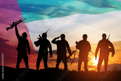 Silhouettes of soldiers on background of UAE flag and the sunset or the sunrise. Concept of national holidays. Commemoration Day.