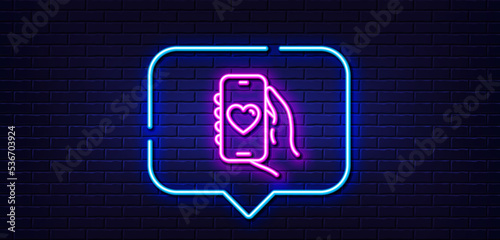 Neon light speech bubble. Dating app line icon. Hand hold phone sign. Cellphone with screen notification symbol. Neon light background. Dating app glow line. Brick wall banner. Vector