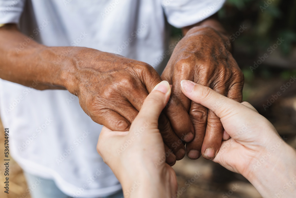 Fototapeta premium Close-up of elderly caregiver and daughter's hands.