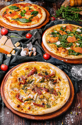 Three Different Pizzas on wooden table