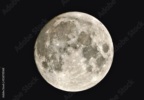 full moon shining with reflected light on a black background, visible craters, darker spots