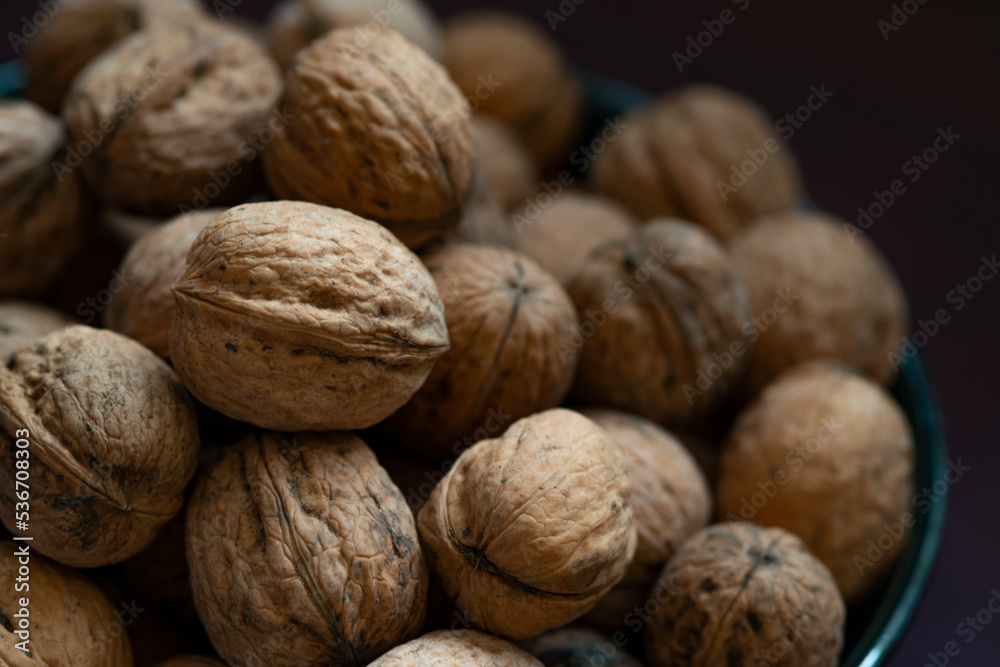 Bowl full of walnuts on black background with copy space Bowl full of walnuts on black background with copy space