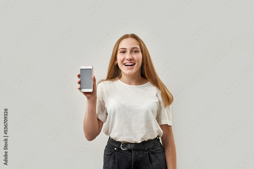 Smiling caucasian female teenage show mobile phone Smiling caucasian female teenage show mobile phone
