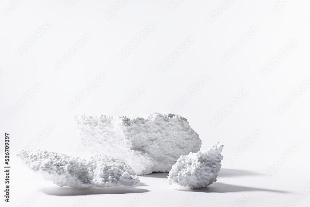 White podiums mockup of styrofoam as abstract snowy cliffs for presentation cosmetics products or goods in sun beam with glare. Template stage in rough industrial fashion style. White podiums mockup of styrofoam as abstract snowy cliffs for presentation cosmetics products or goods in sun beam with glare. Template stage in rough industrial fashion style.