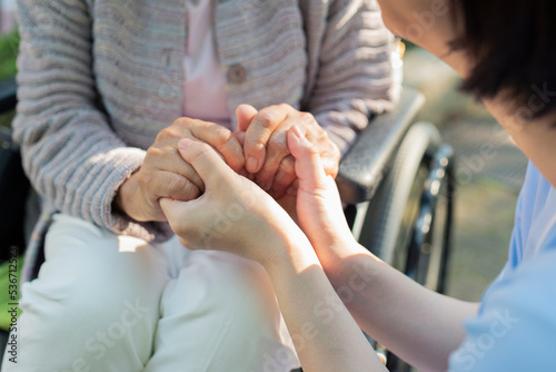 Fototapet シニア女性の手を握る介護士の手元