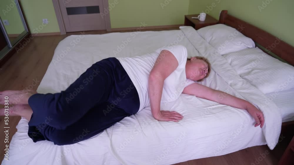 over weight blond middle-aged woman suffering from back ache on the bed, healthcare and problem, Woman rubbing aching back over weight blond middle-aged woman suffering from back ache on the bed, healthcare and problem, Woman rubbing aching back