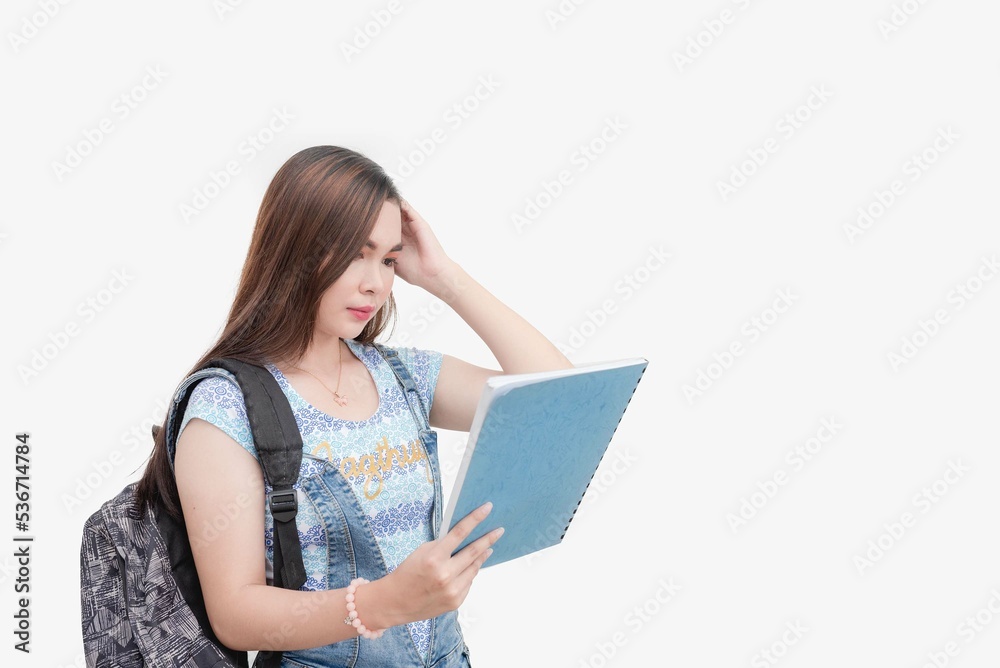 A college school girl holding a work book scratches her head as she is confused with the lessons. Studio shot isolated white background. A college school girl holding a work book scratches her head as she is confused with the lessons. Studio shot isolated white background.