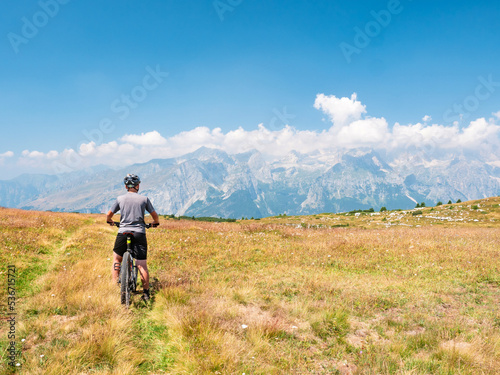 Boy stop bike on peak trek and enjoy overview over Alps peak © rdonar