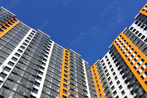 Fotografering New residential building with orange and white cladding against blue sky