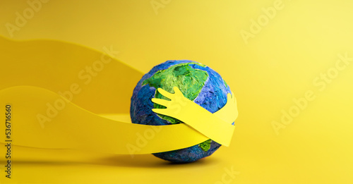 Fototapeta Naklejka Na Ścianę i Meble -  World Earth Day Concept. Green Energy, ESG, Renewable and Sustainable Resources. Environmental Care. Paper Cut as Hands Embracing Green Globe. Top View