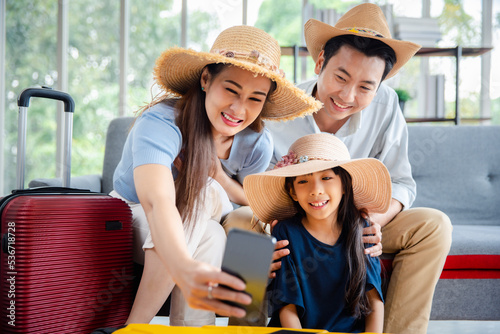 Young happy family asian father mother and daughter taking selfie photo exciting preparing luggage suitcase booking online ticket and hotel for vacation holiday travel trip