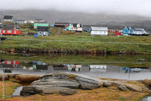 Colorful houses in the small town of Qeqertarsuaq that are reflected in the water, Greenland, Denmark    photo