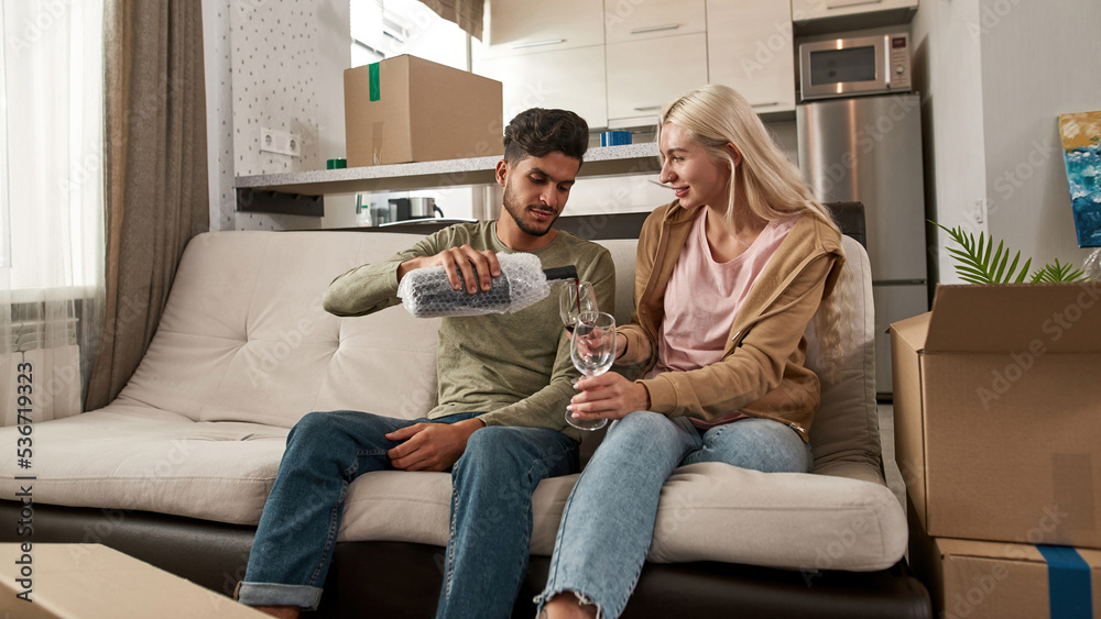 Man pouring wine in glasses in hands of girl