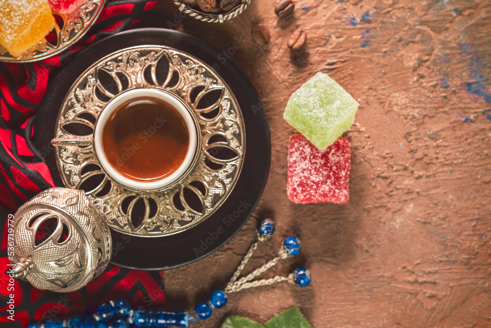 Turkish coffee cup placed with roasted coffee beans, Turkish delights and rosary beads on rustic background. Top view with copy space. Turkish coffee cup placed with roasted coffee beans, Turkish delights and rosary beads on rustic background. Top view with copy space.