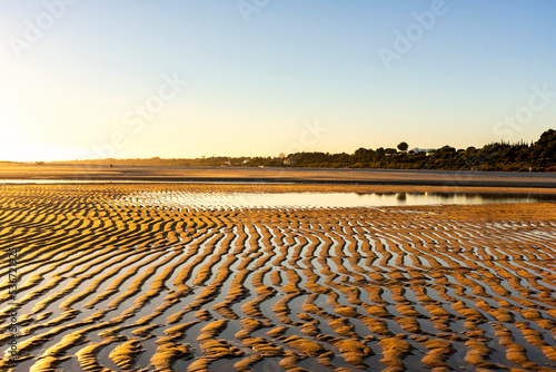 Valokuva Low tide at the beach in Portugal at hot weather with the sunset and small water