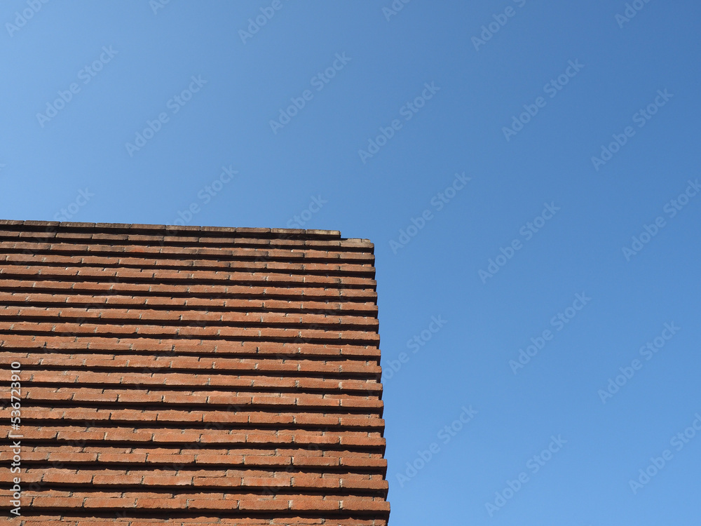red brick wall over blue sky background red brick wall over blue sky background