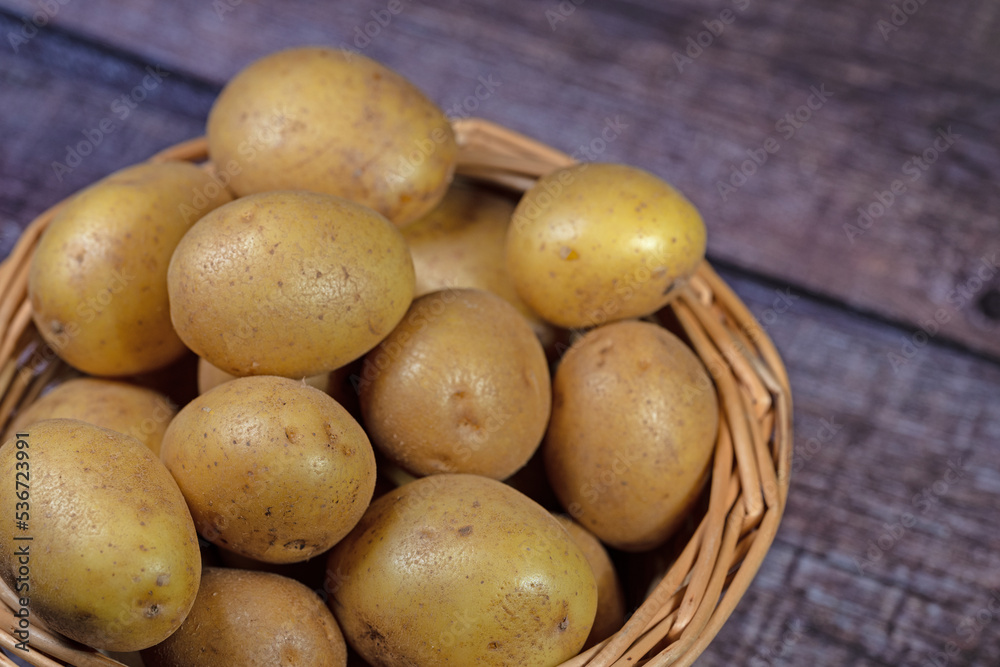 Kartoffeln im Korb auf hölzernen Untergrund Kartoffeln im Korb auf hölzernen Untergrund