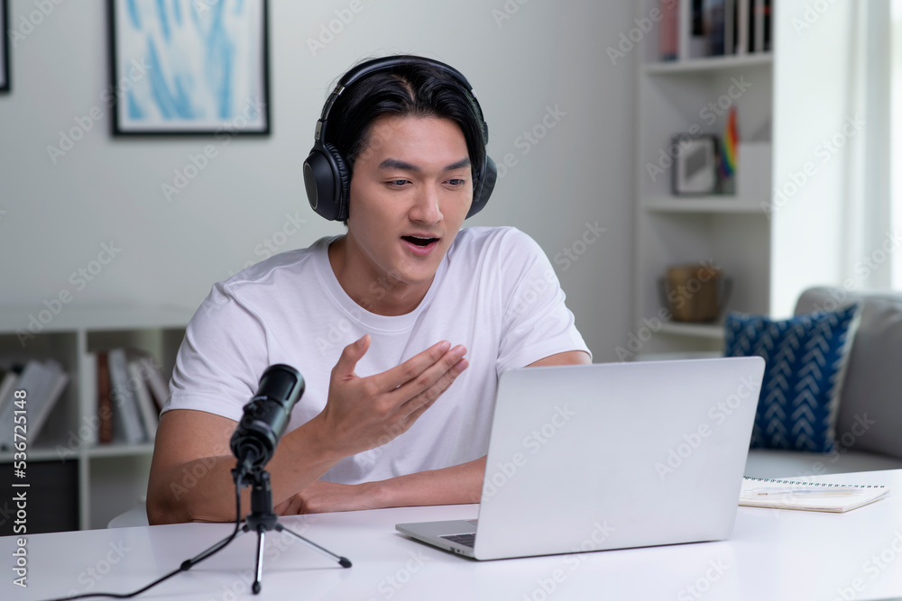Focused young Asian business person, entrepreneur, speaker, student, office worker wearing headphones, looking at laptop screen and speaking in video conference call, giving lecture, joining online