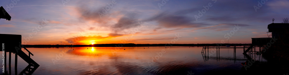 Panorama of beautiful colorful sunset with houses in the front at Ammersee Bavaria Germany