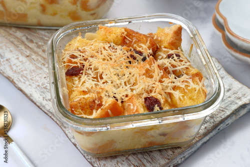 Homemade bread butter pudding with raisins and grated cheese as topping