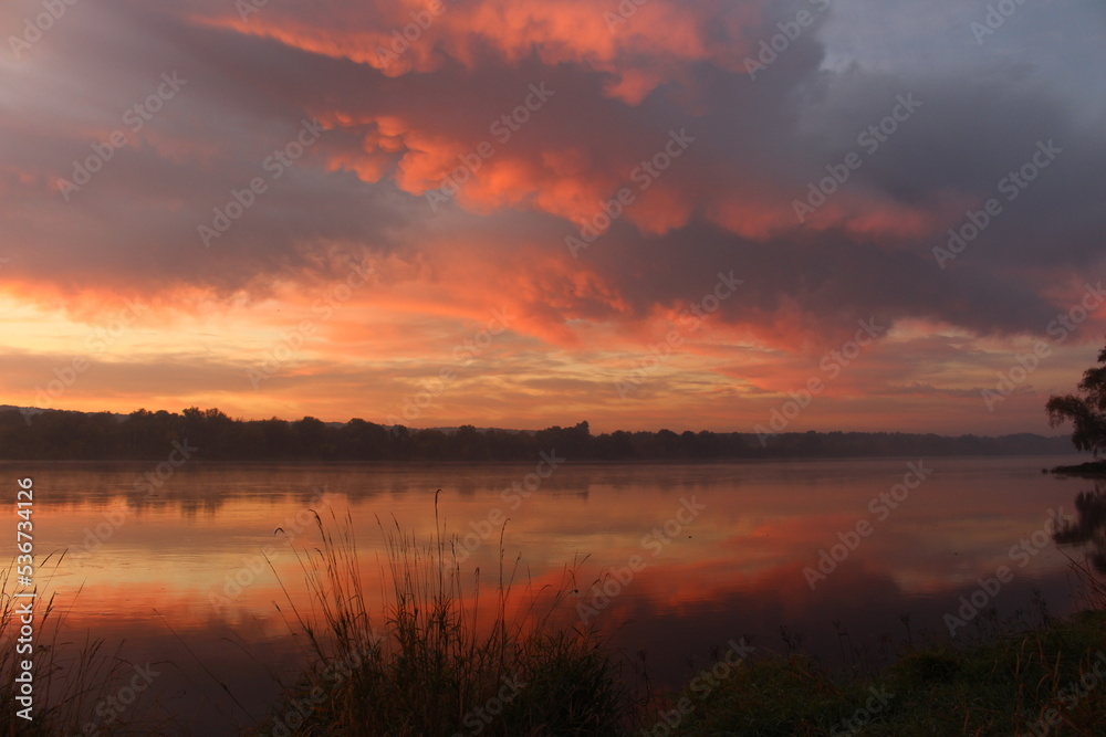 Piękny wschód słońca nad rzeką w jesienny poranek.