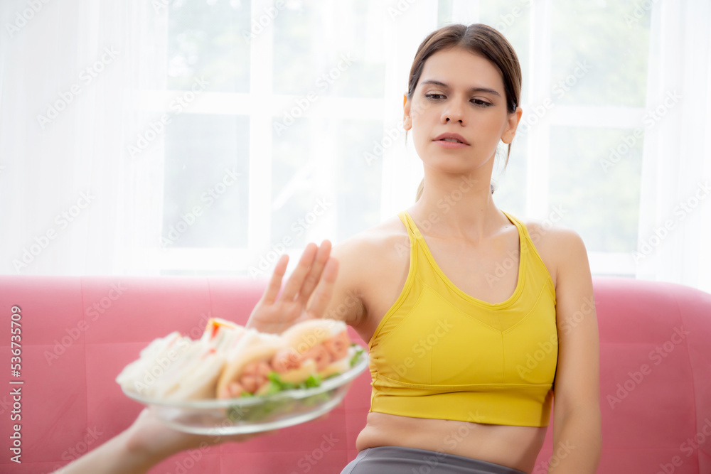 Hands serving food and young caucasian woman making sign say no food unhealthy with obese, woman refuse and push out food with temptation for dieting, nutrition and fast food a bad, health concepts.