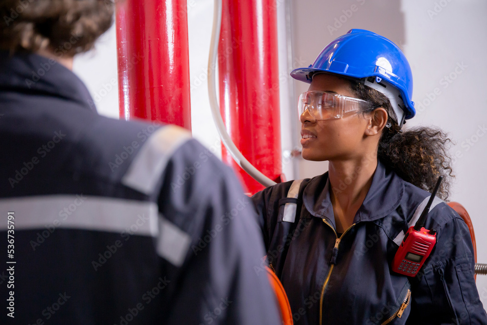 Obraz premium Young woman and man engineer check and examining pipeline and discussion in the factory, mechanic or technician inspector plumber valve and talking together, industrial and maintenance concept.